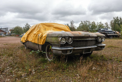 Vintage car on field against sky