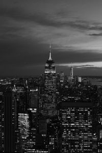 Modern buildings in city against cloudy sky