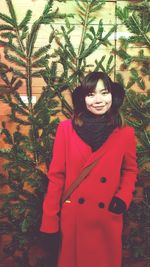 Portrait of smiling young woman standing in snow