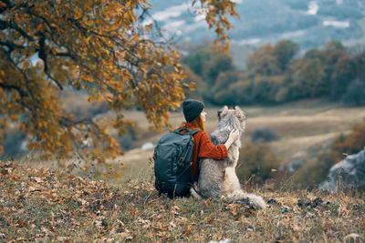 Rear view of man standing on land during autumn