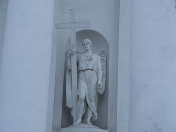 Statue against white wall of building