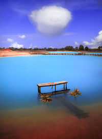 Lifeguard hut by swimming pool against sky