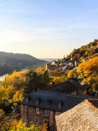 Houses by mountain against sky during autumn