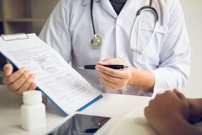 Midsection of man holding hands on table