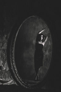 Reflection of woman in mirror against wall