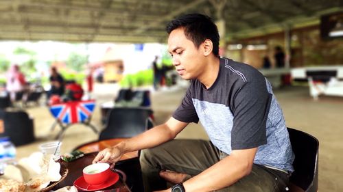 Young man looking away while sitting