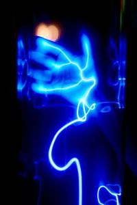 Close-up of illuminated blue light against human hand