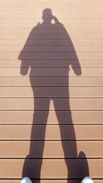 Shadow of man and woman standing on tiled floor