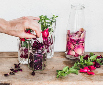 Cropped hand of woman holding drink on table