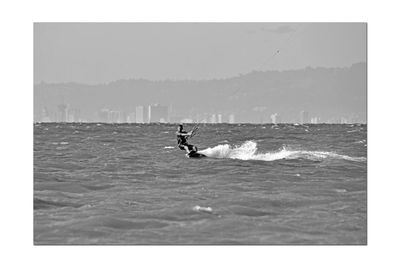 Man surfing in sea against sky