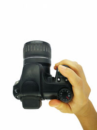 Close-up of hand holding camera against white background