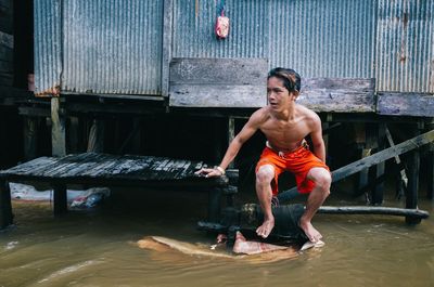 Portrait of shirtless young man in water