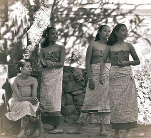 Women with teenage girl in traditional clothing against wall