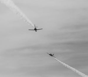 Low angle view of airplane in flight against sky