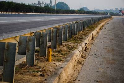 Empty road amidst trees on field