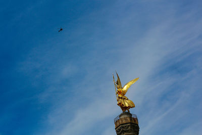 Low angle view of angel statue against sky