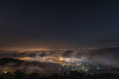 Illuminated city against sky at night