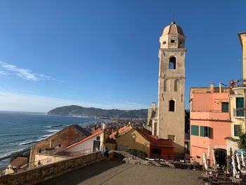 View of buildings by sea against sky