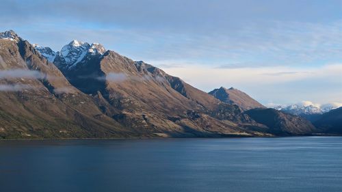 Calm lake against mountain range