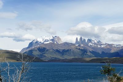 Scenic view of sea and snowcapped mountains against sky