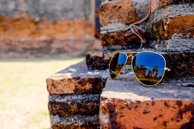 Close-up of sunglasses on retaining wall