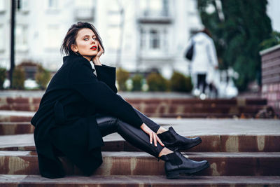 Portrait of young woman sitting outdoors