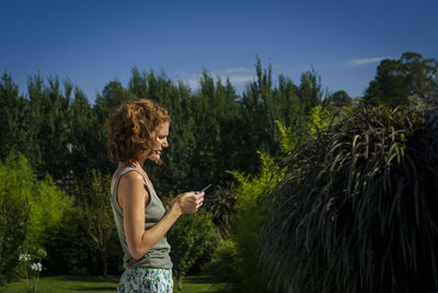 Side view of woman standing against sky