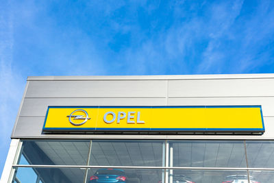 Low angle view of information sign against blue sky