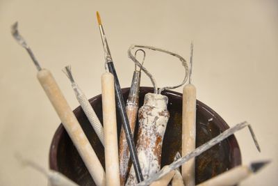 Close-up of ceramic tools on table against white background