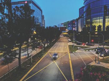 Cars on city street against sky