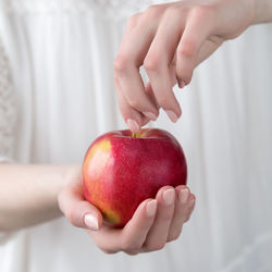 Midsection of woman holding apple