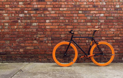 Bicycle leaning against brick wall