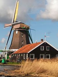 Traditional windmill on house against sky