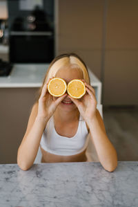 Cropped hands of woman holding orange fruit