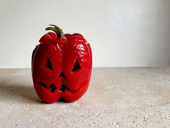 Close-up of red bell pepper on table against wall