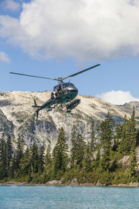 Low angle of helicopter flying over remote lake.