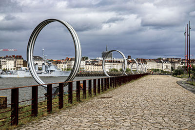 Bridge over river against sky in city