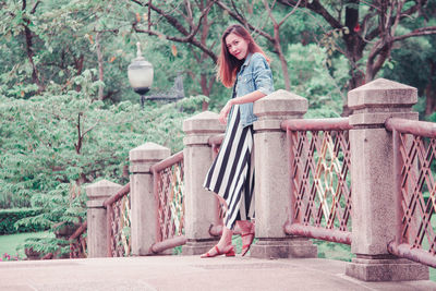 Woman sitting on bench in park