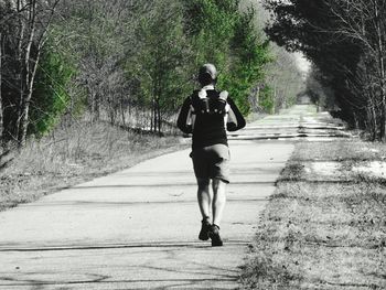 Rear view of woman walking on footpath