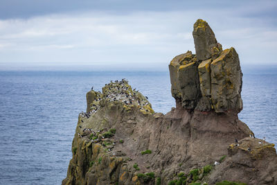 Rock formations by sea against sky