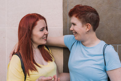 Female friends talking by wall