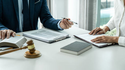 Midsection of lawyer working on table