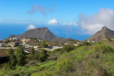 Landscape with green plants in the front, houses and mountains in background on tenerife