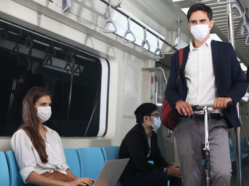 Young man and woman sitting in train