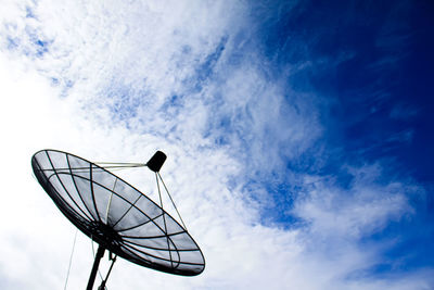Low angle view of satellite dish against cloudy blue sky