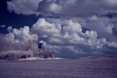 Scenic view of water tower on land against sky