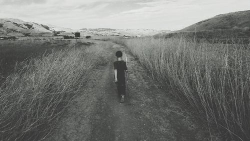 Full length of woman standing on mountain against sky