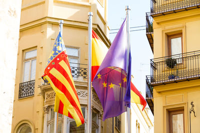 Low angle view of flags hanging on building