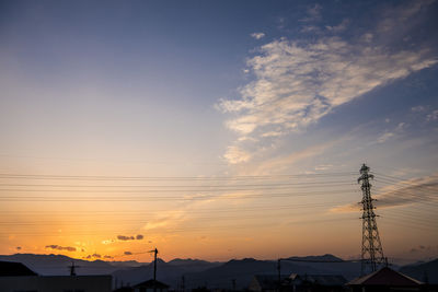 Low angle view of silhouette electricity pylon against sky during sunset