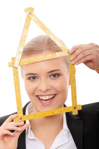 Close-up portrait of smiling young woman against white background